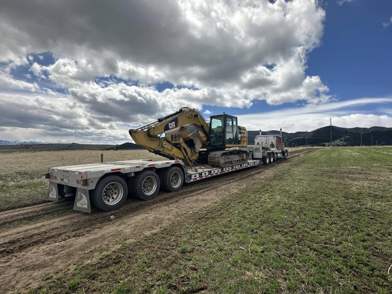 Excavator loaded on trailer arriving at excavation job site in Butte Montana