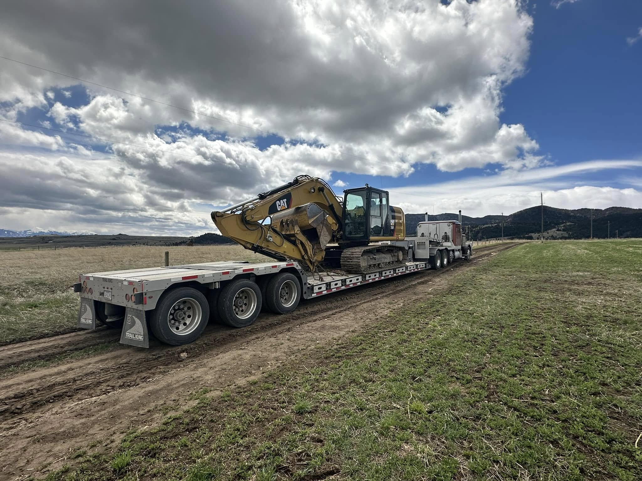 Excavator loaded on trailer arriving at excavation job site in Butte Montana